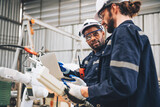 Specialist robotic engineers maintenance and control robot arm in factory warehouse, Testing new innovation automation robo for industrial.African american and caucasian man teamwork working together.