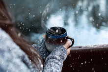 Woman With Long Brown Hair Warming Up With Big Mug Of Hot Chocolate On Snowy Day In Mountains At The Lake	