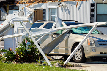 Poster - Destroyed by hurricane Ian suburban house and damaged car in Florida mobile home residential area. Consequences of natural disaster