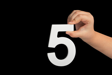 Aufkleber - Number five in hand isolated on black background. Number five in the hand of a child holding on a black background. To be inserted into a project or design.