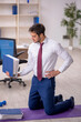 © Elnur - Young male employee doing sport exercises during break