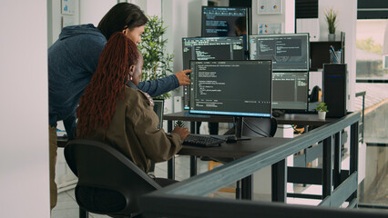 diverse team of ai cloud programers talking about coding script in front of computer, working on ser