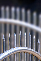 Wall Mural - Close up of stainless steel spike gate fence with blurred background in vertical frame