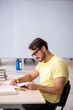 © Elnur - Young male student preparing for exams in the classroom