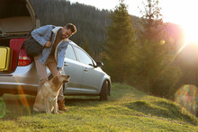 Happy Man And Adorable Dog Near Car In Mountains. Traveling With Pet
