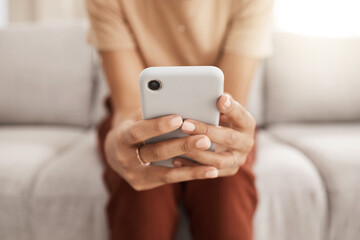 Hands, phone and communication with a black woman typing a text message or browsing social media in her home living room. Contact, mobile and networking with a female reading an email in the house