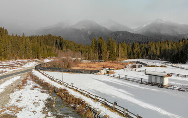 Wall Mural - Dolomites in Italy. Alps in winter with forest and river, aerial view