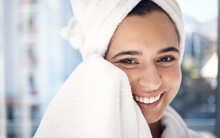 Face, shower and hygiene with a woman in the bathroom of her home for cleaning, wellness or skincare. Portrait, smile and towel with a happy female drying her skin after washing or facial cleansing