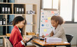 © Nuttapong punna - Businesswomen work and discuss their business plans. A Human employee explains and shows her colleague the results paper in modern office..