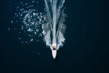 White Big Super Speedboat Top View. White Boat Fast Moving On Dark Blue Sea Aerial View.