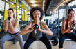 © NDABCREATIVITY - Group of fit people lifting dumbbells during an exercise class at the gym