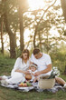 © andriyyavor - Young family with cute little daughter walking in forest on the sunset