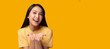 © Nutlegal - Happy beautiful young asian woman stand over yellow background holding copy space imaginary on beauty palm for insert advertisement, happiness and smile face Smiling beautiful asia girl portrait