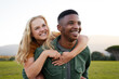 © StratfordProductions - Happy multiracial young couple smiling and looking away during piggyback in field