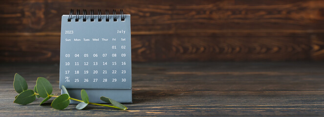 Flip paper calendar and eucalyptus branch on wooden background with space for text