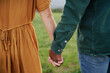 © StratfordProductions - Close-up of multiracial young couple in casual clothing holding hands in field
