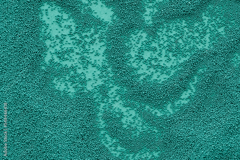 Small beads scattered on green background