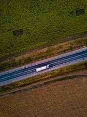 Wall Mural - Aerial Top View of White Truck with Cargo Semi Trailer Moving on Road in Direction