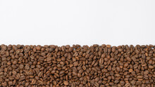 Coffee Beans Laid Out In One Wide Row On A White Background, Place For Inscription And Advertising.