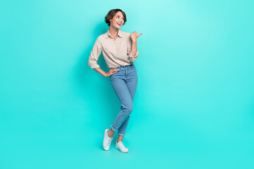 Poster - Full length photo of positive lady trendy clothes arm direct ad interested look empty space information isolated cyan color background