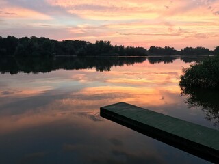 Canvas Print - Mesmerizing shot of pinkish sunset at a lake with the silhouette of the trees and a jetty walk