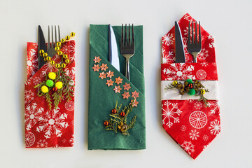 Wall Mural - Red and green color, christmas pattern paper christmas napkins various folded with cutlery set on white surface