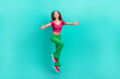 © deagreez - Full length photo of pretty charming schoolgirl wear pink crop top flare trousers jumping high open arms isolated turquoise color background