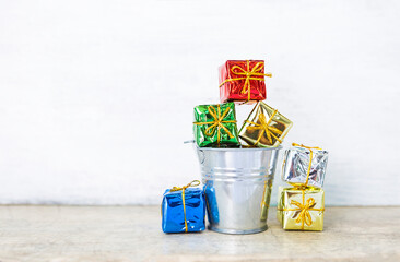 Shiny color gift box in metal bucket with space on white background, Christmas and New year concept background