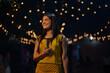 © IndiaPix - Portrait of a young woman standing on the street at night