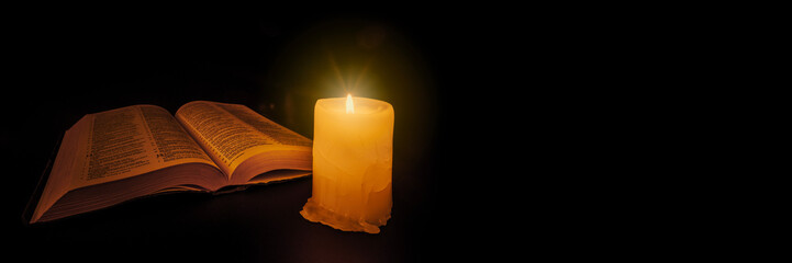 Wall Mural - bible on the table in the light of a candle