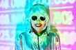 © ADDICTIVE STOCK - Futuristic woman in sunglasses standing in studio with projector lights