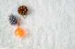 pomarańczowa bąbka,dwie szyszki na śniegu,widok z góry,miejsce na tekst,tło do projektów światecznych,minimalistyczna tapeta