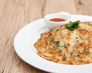 Wall Mural - Thai style omelette with minced pork, 
coriander and onion served with chilli sauce or Sriracha sauce