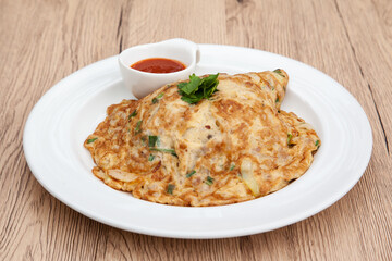 Wall Mural - Thai style omelette with minced pork, 
coriander and onion served with chilli sauce or Sriracha sauce