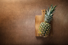 Pineapple. Whole Pineapple On Brown Background, Top View