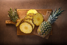 Pineapple. Sliced And Whole Pineapple On Brown Background, Top View