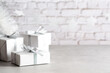 White presents with silver ribbons and silver stars on grey and white background. Copy space. 