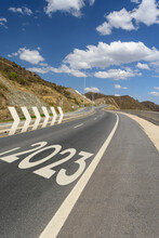 Año Nuevo 2023 O Concepto De Inicio. Palabra 2023 Escrita En La Carretera Con Curvas Y En Ascenso. Flechas En 3D. Concepto Positivo De Desafío Y Cambio.