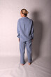 © Шамиль Алиев - A young girl in a homemade suit in the studio on a white background is standing with her back