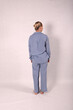 © Шамиль Алиев - A young girl in a homemade suit in the studio on a white background is standing with her back