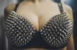 Tits close up with sexy bdsm spiked bra. Bdsm Concept. Side view. Copyspace. Part of body.