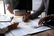© crizzystudio - Asian business colleagues meeting to analyze financial reporting situation Investment and accounting concept sitting table and pointing at document. Profit chart. Graph showing growth.
