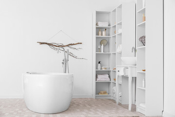 Poster - Modern bathtub, sink and shelf units with bath accessories near white wall