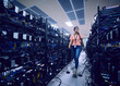 © Tetra Images - Female technician walking in server room