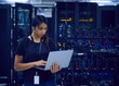 © Tetra Images - Female technician using laptop in server room
