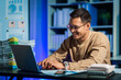 © NanSan - Overtime work concept, Handsome asian business man working late at night in office workplace.