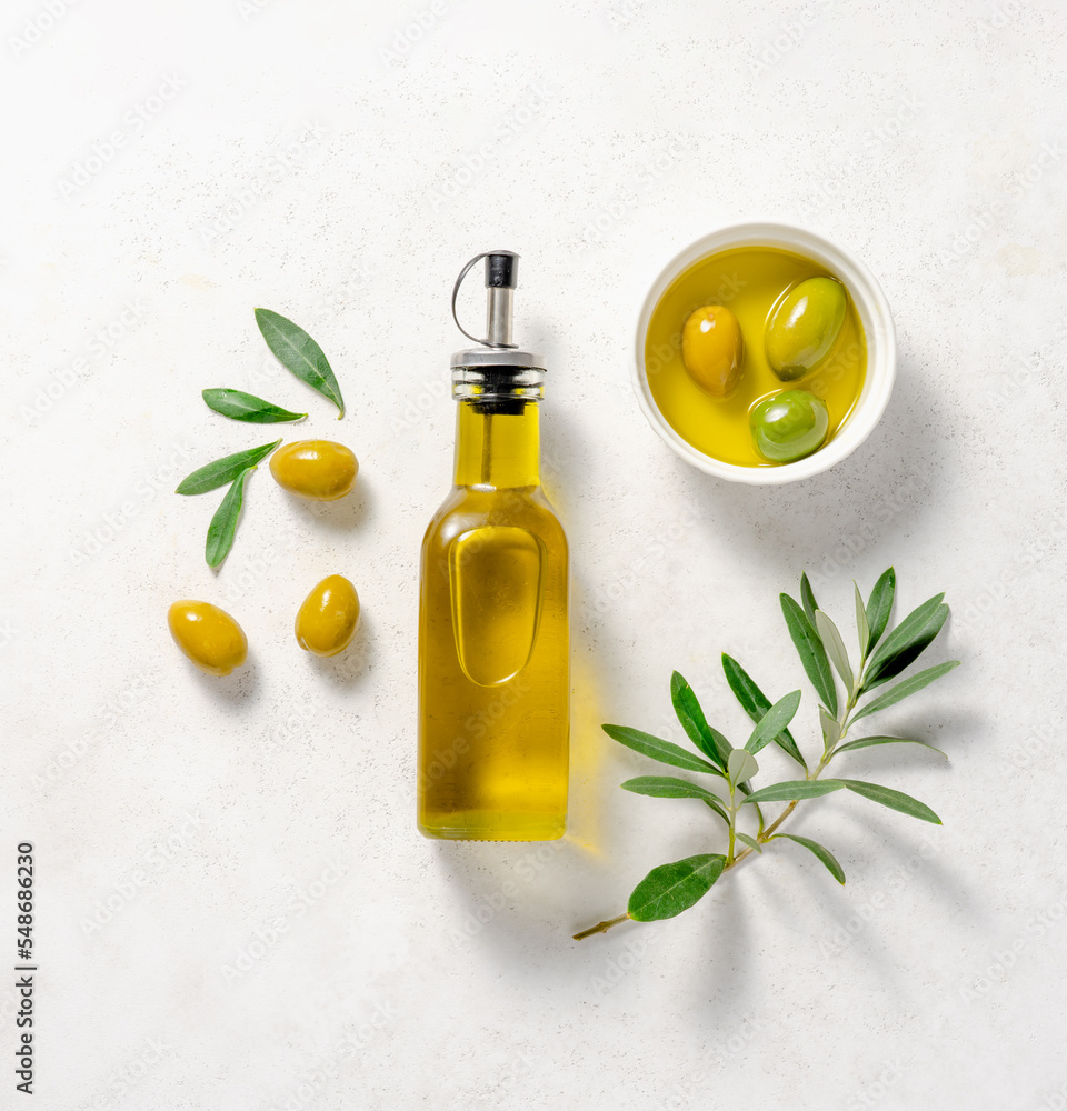 Olives and olive oil in white bowl. Bottle of olive oil with olive ...