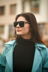 Wall Mural - A confident and beautiful woman wears expensive sunglasses. Concept of luxury accesories for woman. Stylish brunette girl in the city