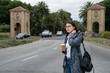 © PR Image Factory - asian Japanese woman exchange student gazing into space with coffee while waiting her classmate at the entry of school university in California usa