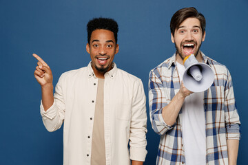 Wall Mural - Young two friend happy fun men wear white casual shirts together hold scream in megaphone announces discounts sale Hurry up look aside on workspace area isolated plain dark royal navy blue background
